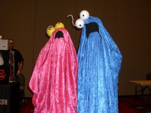 Two people dressed as the yip yip aliens from Sesame Street.